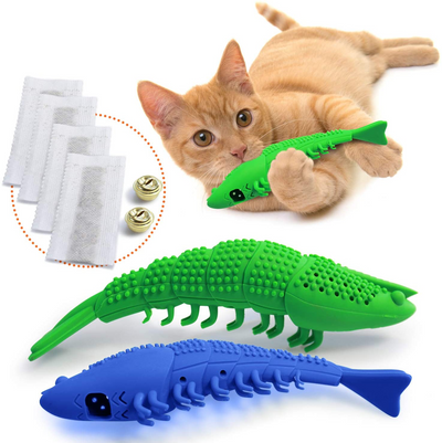 Green silicone pet cat toothbrush toy shaped like a fish, shown with a playful orange cat and included replacement pads and bells.