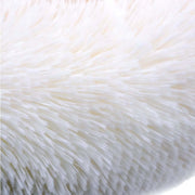 Close-up of soft white plush fabric on a dog sofa bed providing orthopedic comfort and support