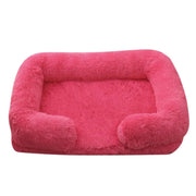 Soft pink orthopedic dog sofa bed with plush cushioning and raised edges for medium-sized dogs