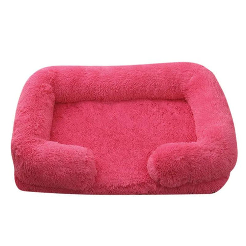Soft pink orthopedic dog sofa bed with plush cushioning and raised edges for medium-sized dogs